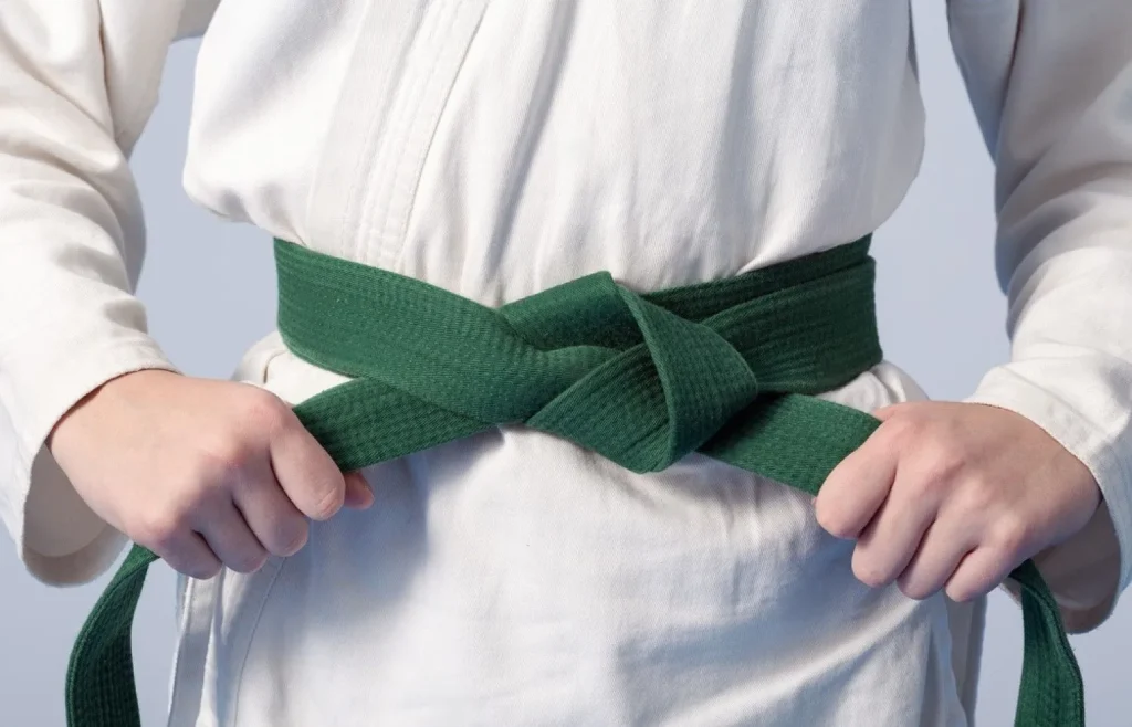 -hands-tightening-green-belt-on-a-teenage-dressed-in-kimono-1920w